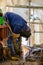 Welding worker with a radial saw on a construction site