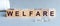 Welfare sign made of wooden cubes on a grey desk