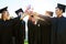 Well accomplish more great things from here on. a group of students holding their diplomas together on graduation day.