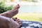 Well cared feet of sunbathing woman laying on deck chair close up with nature background