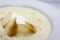 Well-cooked thinly sliced croutons in a creamy soup mashed butter in a white plate
