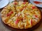 Well-done fresh appetizing crab stick, ham, cheese pizza being served on a wooden tray, ready to eat