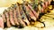 Well-done grilled marinated beef flank steak on wooden board