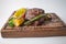 Well done steak with grilled vegetables on wooden board