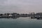 Well lit boat house behind empty docks on calm water with overcast sky