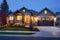 a well-lit exterior shot of craftsman home at dusk with wooden doors and stone walls