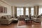 A well-lit modern elegant spacious living room with hardwood floors - two couches - chairs and elegant decor
