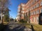 Well-lit sidewalk in front of an elegant residential apartment building on a bright, sunny day