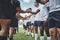 Well played. a group of young rugby players shaking each others hands to congratulate in playing a good game outside on