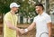 Well played. a handsome young male tennis player shaking hands with his coach outside on the court.