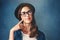 Well thats interesting...Studio shot of an attractive young woman looking thoughtful against a blue background.