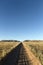 Well used, Dusty desert road to nowhere. Southern Namibia. Mountain scenery surrounding. Golden afternoon light.