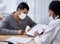 Well work carefully through your rehabilitation plan. a young man going through paperwork during a consultation with a