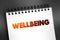 Wellbeing - complex combination of a person\\\'s physical, mental, emotional and social health factors, text concept on notepad