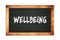 WELLBEING text written on wooden frame school blackboard