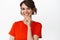 Wellbeing and women beauty. Close up of modern stylish girl smiling pleased, looking thoughtful, standing in red tshirt