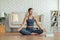 Wellness Athlete Asian indian woman looking laptop practice yoga lotus pose online course at home to meditation comfortable and