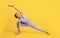 Wellness concept. Fit black woman standing in yoga pose on yellow studio background, full length portrait, free space