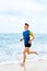 Wellness. Fit Athletic Man Running On Beach,Jogging During Workout.