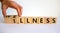 Wellness or illness. Male hand flips wooden cubes and changes the inscription `illness` to `wellness` or vice versa. Beautiful
