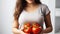 Wellness journey of a slim woman showcasing her belly while holding ripe tomatoes on a white background. Generative AI