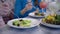 Wellness lifestyle, young women on diet eats greek salad from white plates sitting at the table in cafe