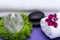Wellness Relax concept with Spa elements. Rolled White Towels, Basalt Stones, Orchid, Clear Quartz Sphere and Dianthus Flowers