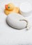 Wellness, rubber duck, pumice stone, cream jar on a white towel