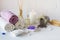 Wellness setting. Purple sea salt, towel, massage oil , lavender flowers and candle on white textured background.