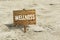 Wellness wooden sign on a beach.