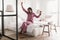 Wellslept Black Lady Stretching Arms Wearing Pajamas Sitting In Bedroom