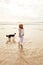 Were both beach lovers. a young woman spending some time with her dog at the beach.