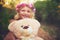 Were both smiling for the camera. a happy little girl holding a teddy bear and looking at the camera while standing in