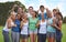 Were committed to fitness. A happy group of young people smiling at the camera while standing on a sportsfield.