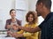 Were eager to see what you can offer our business. Shot of coworkers shaking hands during a meeting in a modern office.