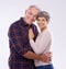 Were still in love. Studio portrait of an affectionate elderly couple against a gray background.