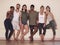 Were young, happy and healthy. Full length shot of a group of active young people posing together against a wall in yoga