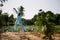 West African Farmer Raising A Full Watering Can From A Rural Well