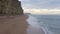 West Bay Beach With Tall Sandstone Cliffs Next the Sea in England