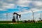 West Texas fuel and energy oil rig and oil pump with wind turbine farm