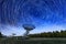 The Westerbork Synthesis Radio Telescope WSRT during dusk, with a light cloudy sky and stars a little visible