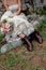 A western brides stylish brown boots holding an elegant flower bouquet. Sitting on a step in a vintage wedding dress