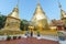 A western couple travelling in a Lanna style Thailand temple, Wat Phra Singh, and looking at the big golden pagoda