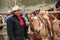 Western cowboy with saddled buckskin horse ready to go roundup horses