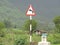 Western Ghats of India- Monsoon season- Direction sign board - lush greenery and cloud covered hills