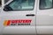 A Western Pest Services truck parked at the side of a street in front of several houses