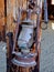 Western style rusty antique broken oil lantern hanging at farm countryside old lamp vintage style hang on wood background.