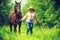 Western woman walking on green meadow with horse