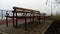 Wet bench on a foggy day. Metal curled wrought iron fence detail. Off-season melancholic mood