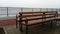 Wet bench on a foggy day. Metal curled wrought iron fence detail. Off-season melancholic mood